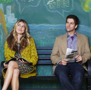 A man and woman sitting on a park bench.